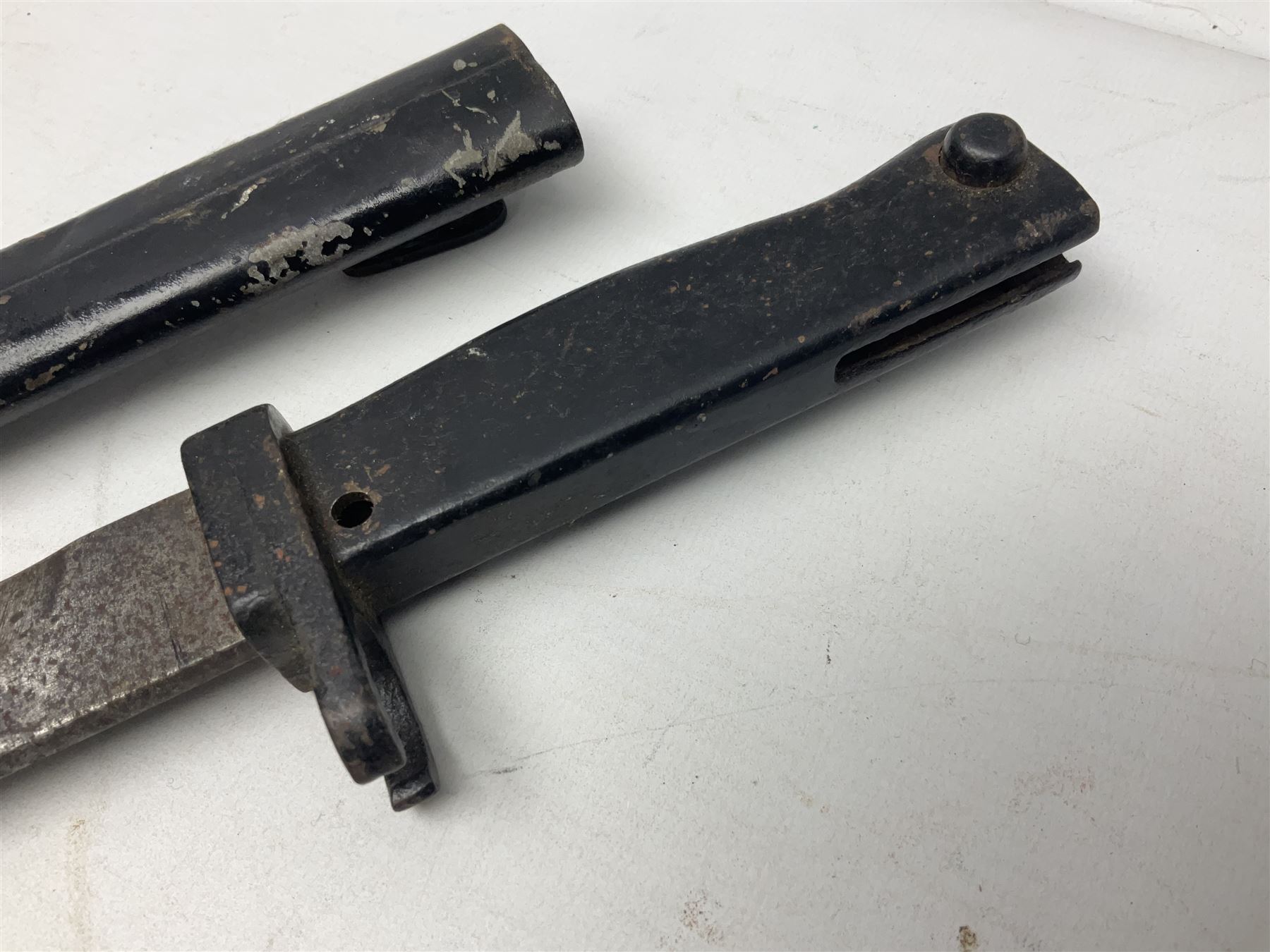British No 7 MKI knife bayonet with 20cm single edged fullered clipped point blade;  blackened steel, large muzzle ring cross-guard; blackened swivelling pommel marked 'F5H'; red Tufnol composite grips; in blackened steel scabbard L33cm overall; British Pattern 1888 bayonet with scabbard; and German Ersatz bayonet with scabbard (3)