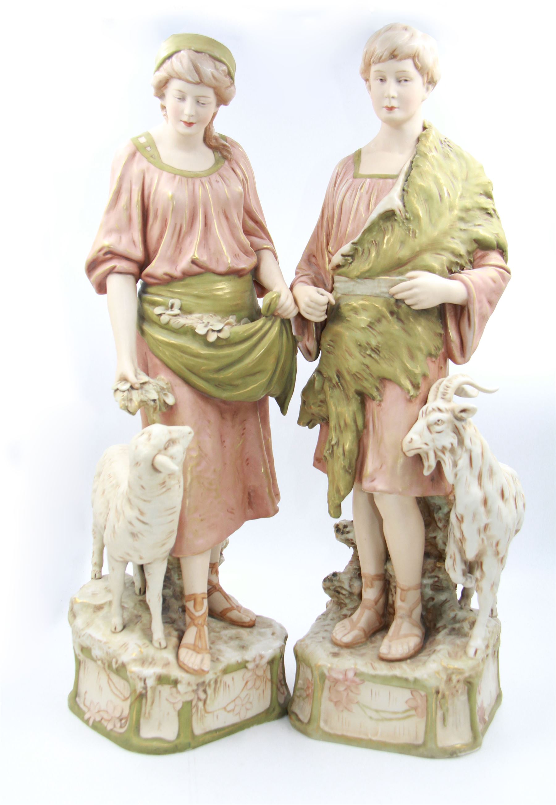 Pair of Royal Dux figures, no. 1115, modelled as a shepherd with a goat by his side and a shepherdess feeding a lamb, each wearing flowing green and pink robes with gilt detailing, with pink triangle mark beneath, H51cm