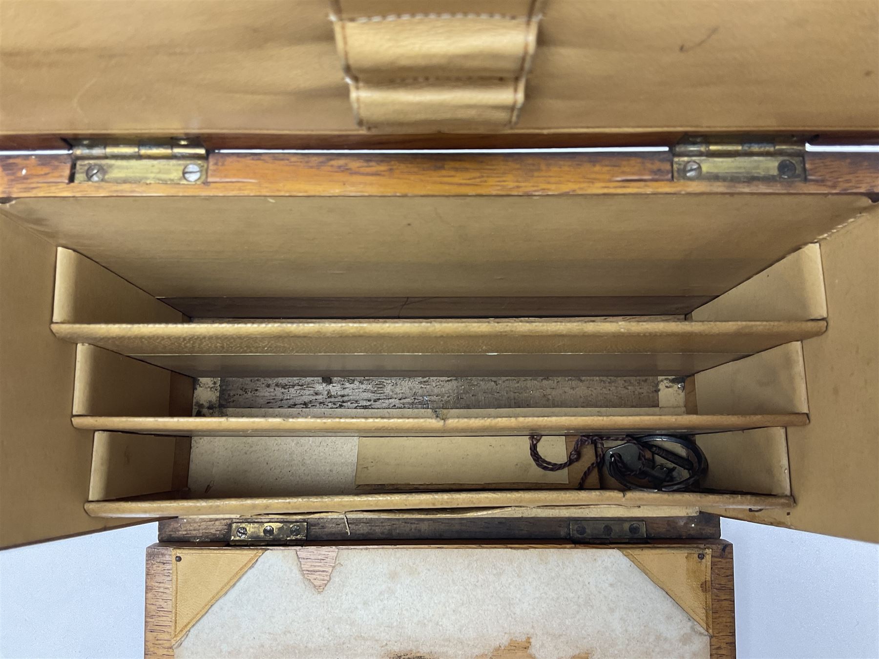 Wooden table stationery box, with drop down front and fitted interior, with metal shield plaque to the hinged lid, H18cm