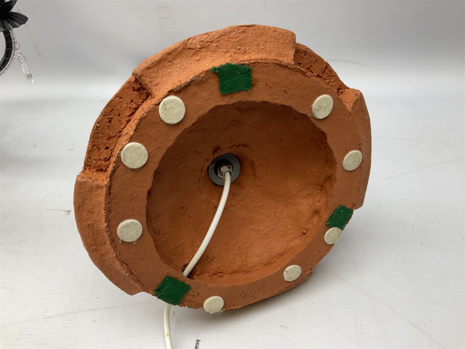 Terracotta studio pottery lamp base with carved detail and geometric knop and base, H45cm, together with a black chandelier with drops, Mid century teak light fitting with three drop down clear glass pendants and copper mounts, H54cm, and Rhinestone and black eight branched chandelier