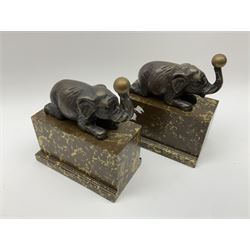 A pair of bronzed bookends, modelled as elephants in recumbent pose, upon marble effect bases, overall H19cm L17.5cm. 