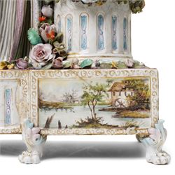 Large19th century  German porcelain mantel clock with white dial and striking movement, the case with a standing figure of Flora resting on a pillar with floral applied decoration, the base painted eith landscape and floral panels on paw feet H77cm W43cm