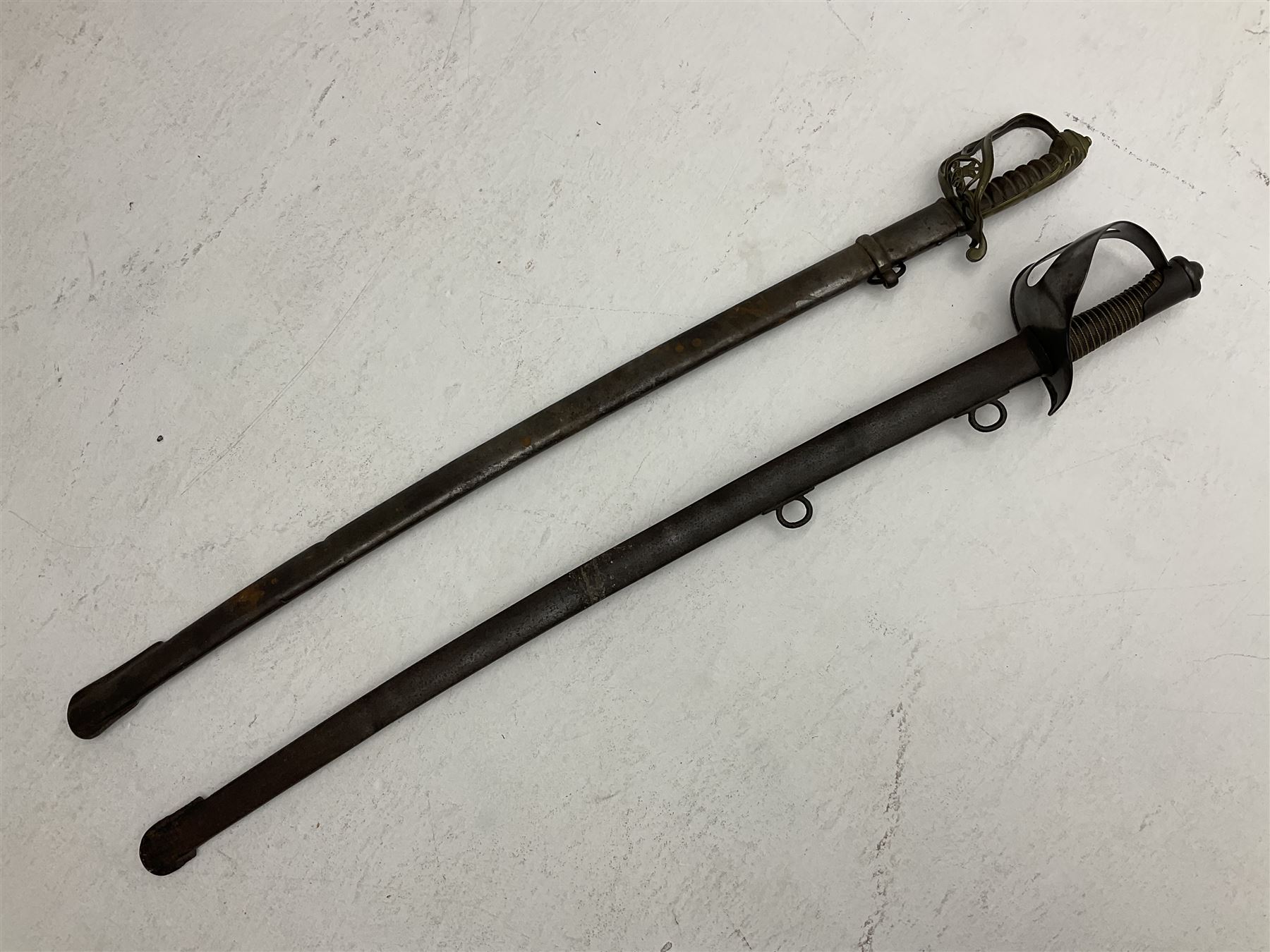 19th century Imperial German army heavy cavalry officers sword by Schnitzler and Kirschbaum, with 89cm single fullered steel blade and sheet steel basket hilt with teardrop cut-out and wire-bound leather grip L107.5cm overall; in steel scabbard with two suspension rings; and British Army 1822 Pattern Infantry Officer's sword in associated scabbard (2)