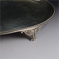 Victorian silver tray, of circular form with beaded rim, engraved to the centre with floral decoration, upon three scroll mounted paw feet, hallmarked Walter & John Barnard, London 1877, D30.5cm