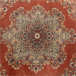 Persian Kashan rug, the rich terracotta field with central floral medallion and palmette spandrels, surrounded by a cream border of stylised boteh and foliate decoration