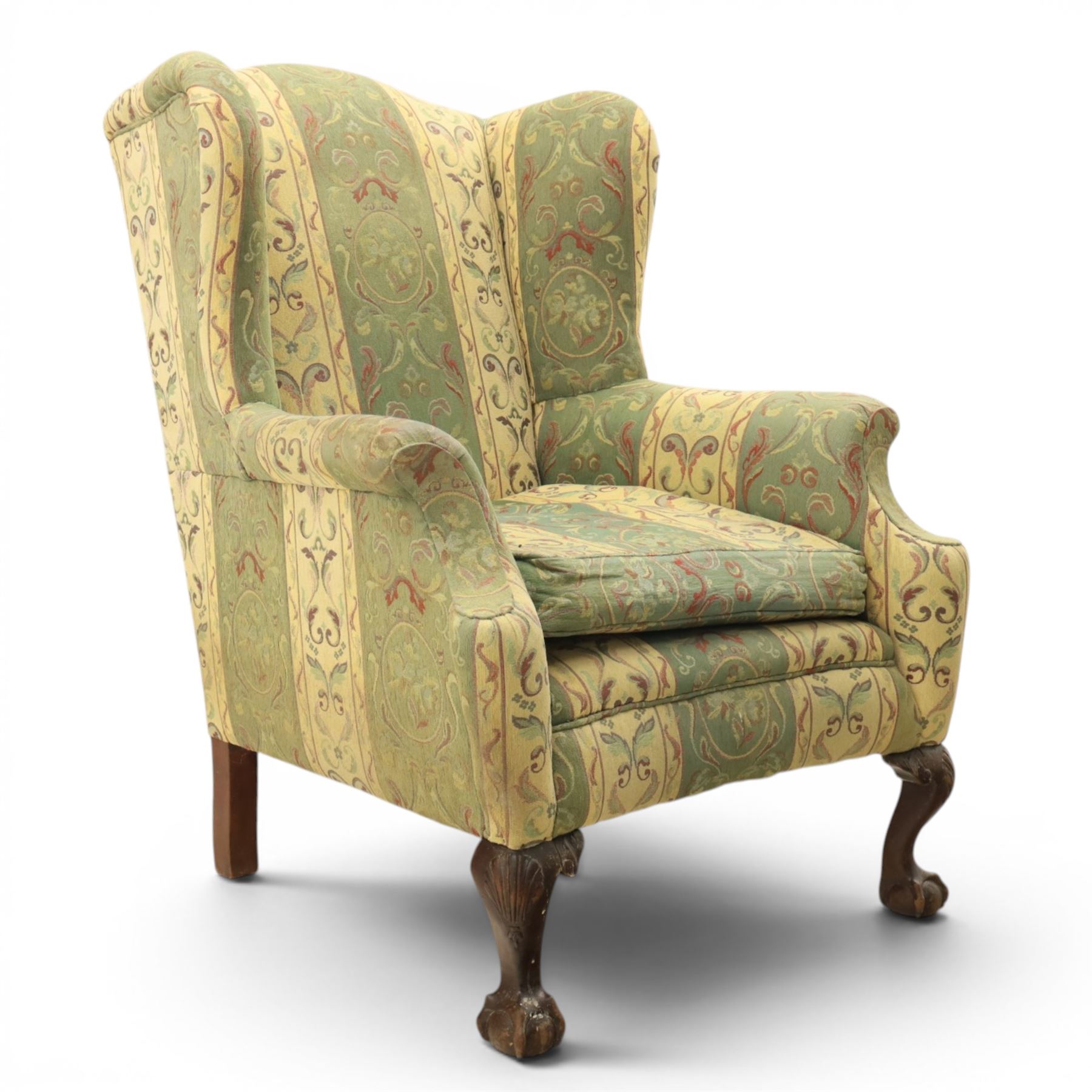 Queen Anne style wingback armchair, upholstered in green and cream foliate fabric, shaped arms on ball and claw feet