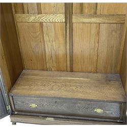 20th century oak triple wardrobe, stepped moulded pediment with carved and fluted decoration, enclosed by central mirror glazed doors and two panelled doors, the interior fitted with drawers and slides, on turned feet