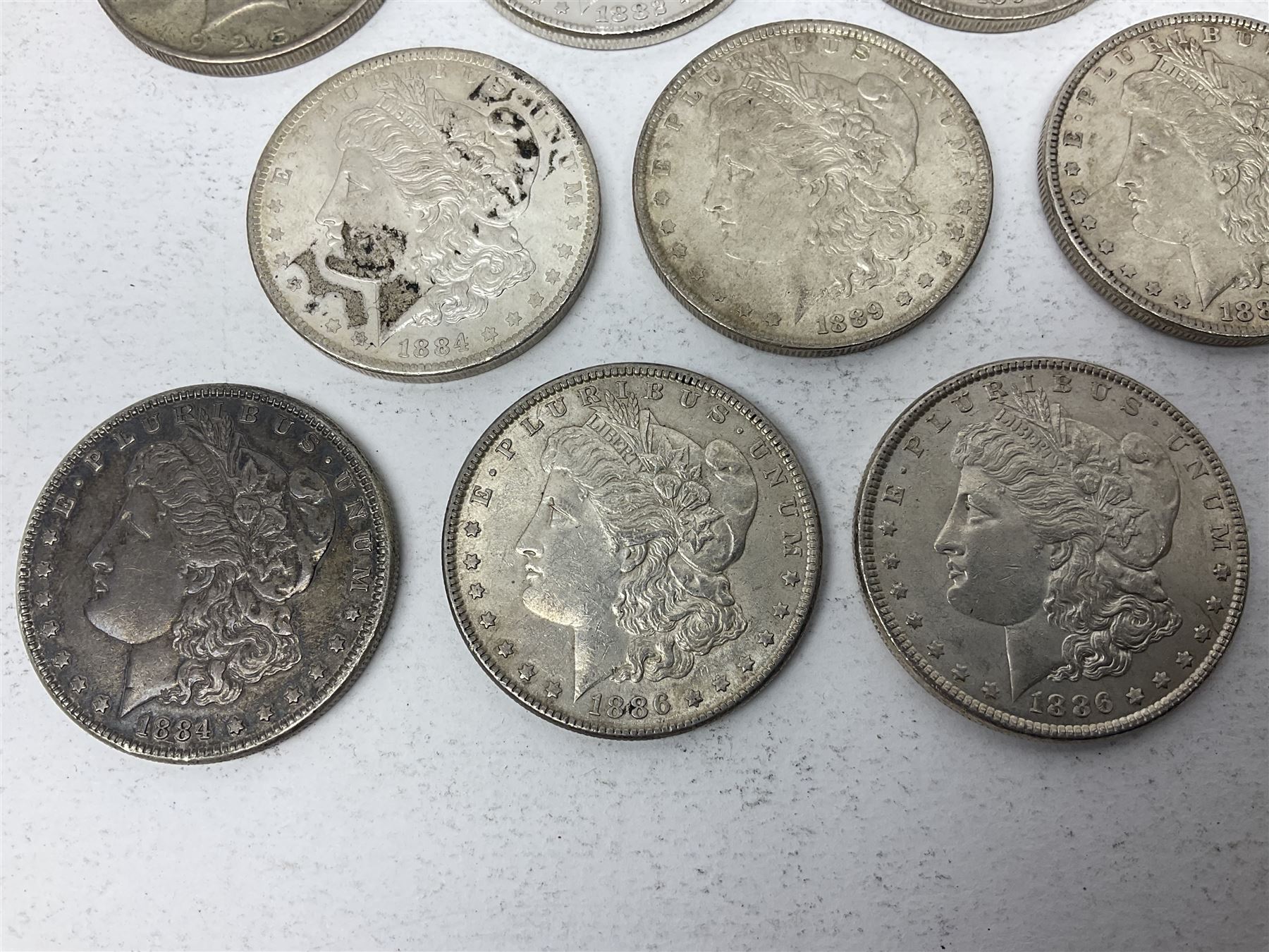 Eight United States of America silver Morgan dollar coins, dated 1882, 1884 O, 1884, 1885, two 1886, 1889, 1890 and a 1925 peace dollar