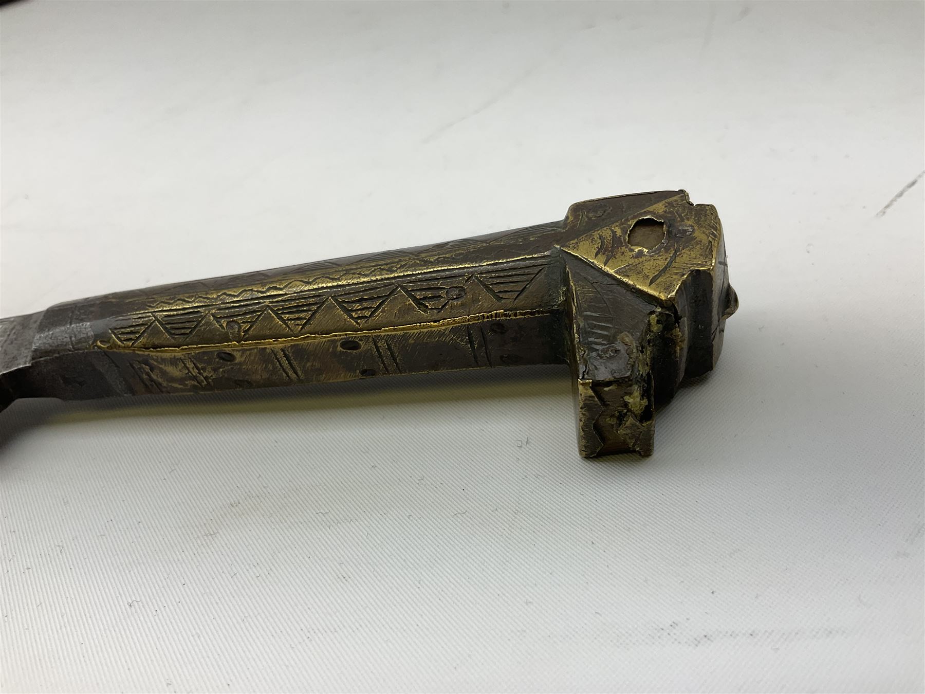 19th century Algerian Flyssa long knife, the 34cm single edged pointed decorative blade inset with yellow metal, chased brass grip with pommel as the snout of a stylised animal and carved hardwood scabbard L45cm overall