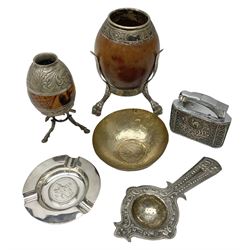 Yerba mate tea gourd calabash cup with silver-plated foliate mounts raised upon three hoof feet, together with silver-plate mounted coconut shell raised upon three pad feet, MYON chromium plated table lighter, Walker and Hall ashtray with five shilling coin to centre, tallest H15cm