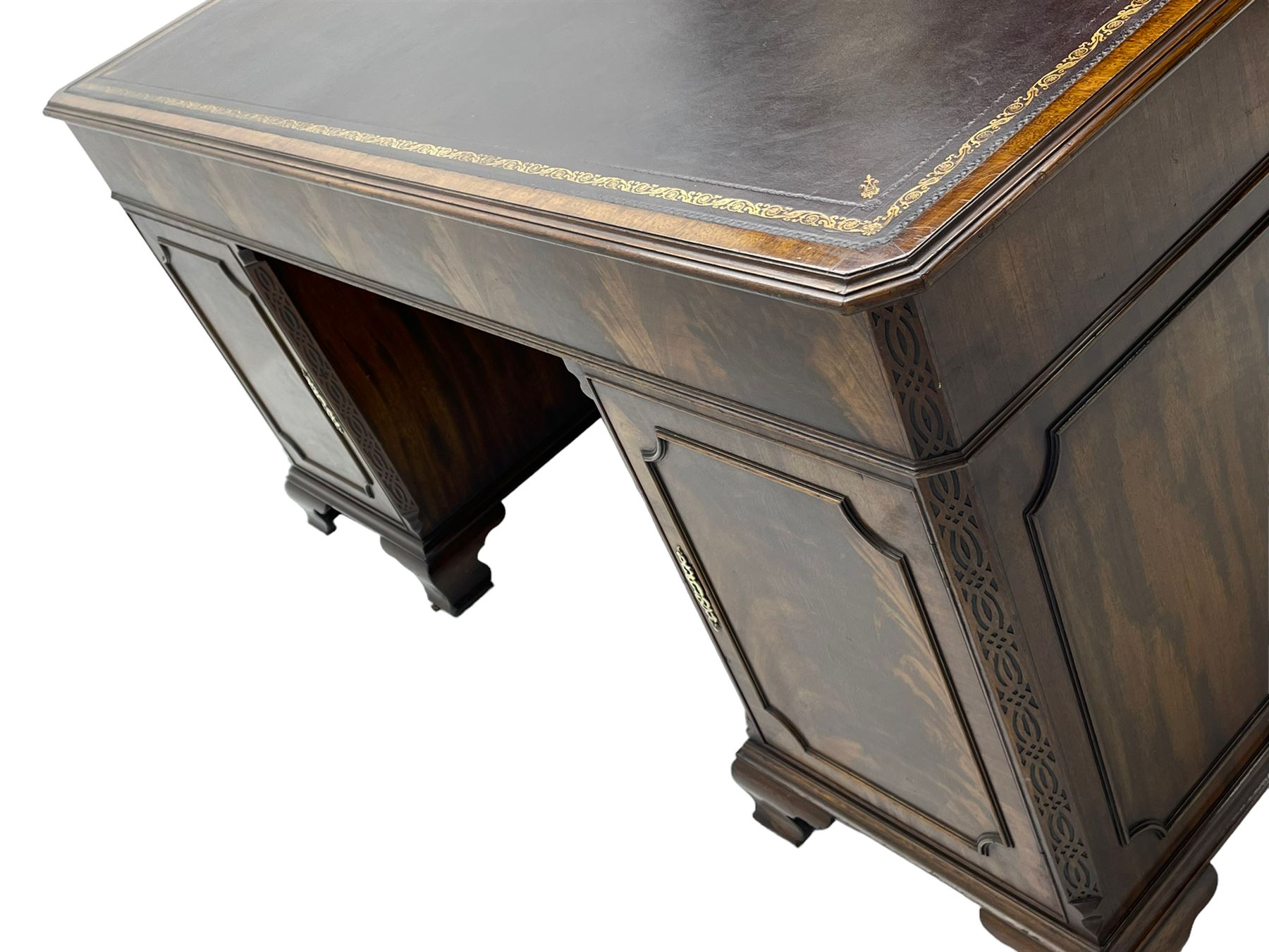 Large Georgian design mahogany twin pedestal partner's desk, moulded rectangular top with canted corners and inset leather writing surface, fitted with nine drawers and two cupboards, the pedestals with canted uprights decorated with blind fretwork, on ogee bracket feet