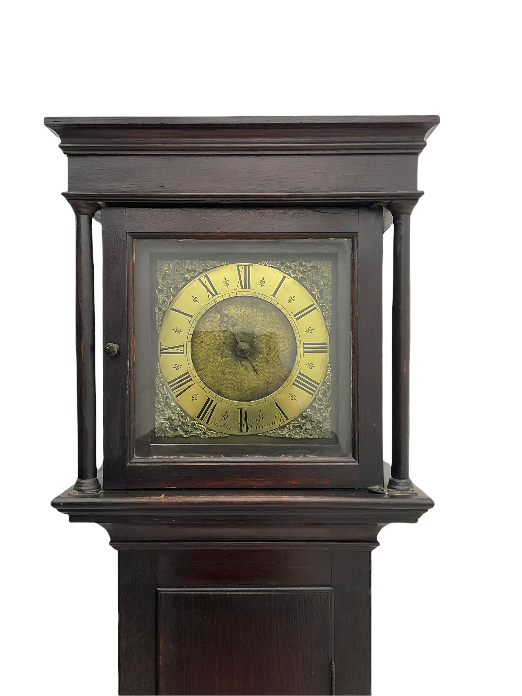 A mid-18th century 30-hour provincial longcase clock by John Darke of Holdsworthy (Devon), in an oak case with a flat-topped pediment, square hood door flanked by two free standing pillars with brass capitals, trunk with a flat-topped full-length door on a rectangular plinth with applied shaped skirting, a 9-1/2” square brass dial with a matted centre and brass (unsilvered) chapter ring, engraved with roman numerals, half and quarter hour divisions, single steel hand and 