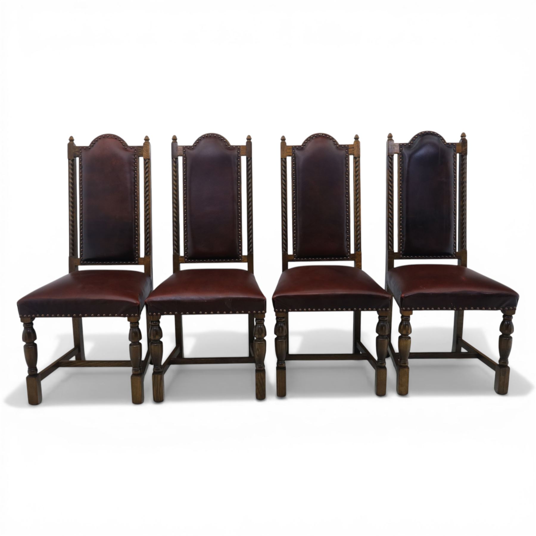 Carolean revival oak dining table and eight chairs (7+1), refectory table with rectangular boarded top and cleated ends, raised on shaped trestle end supports with central stretcher, accompanied by eight high-back chairs including a carver, leather upholstered panels and seats with studwork, on turned legs with stretchers.