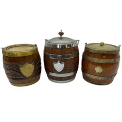 Three 20th century oak tobacco jars in the form of barrels, to include one barrel with brass mounts engravedwith panel of foliage, and another silver-plate coopered example, tallest H20cm