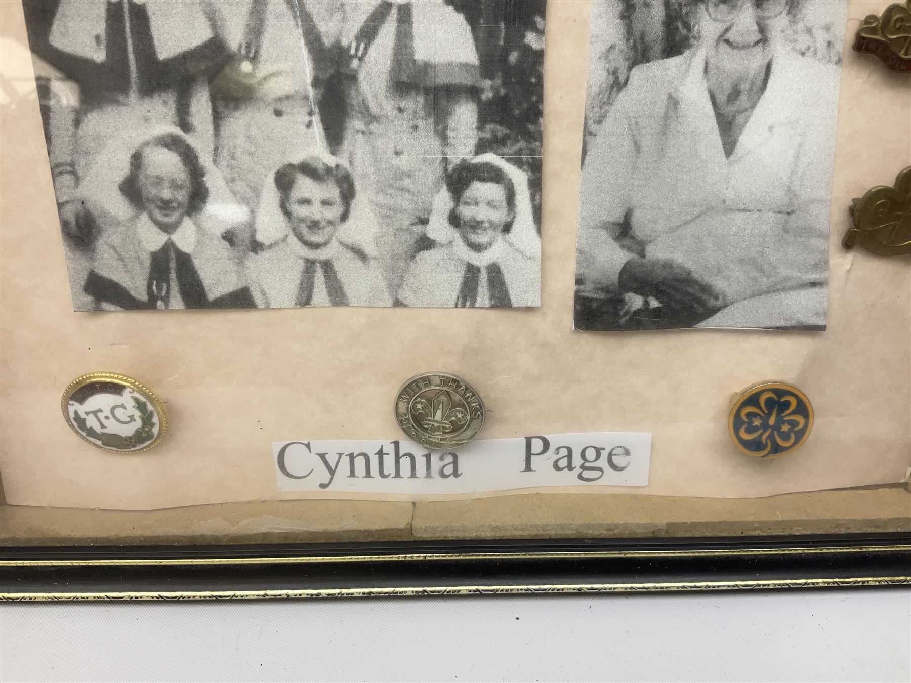 Framed display of medals and badges relating to Captain Cynthia Page of Queen Alexandra's Royal Army Nursing Corps including WW2 War Medal and Defence Medal with miniatures; Red Cross Society 3-Year Service Medal; Q.A.R.A.N.C. cap badge; Girl Guide and silver Scout badges; rank epaulettes; and related photographs 33 x 23cm