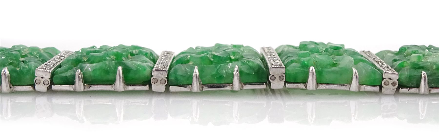 Art Deco platinum and white gold jadeite and diamond bracelet, twelve carved foliate jadeite panels, separated by a row of milgrain set old cut diamonds