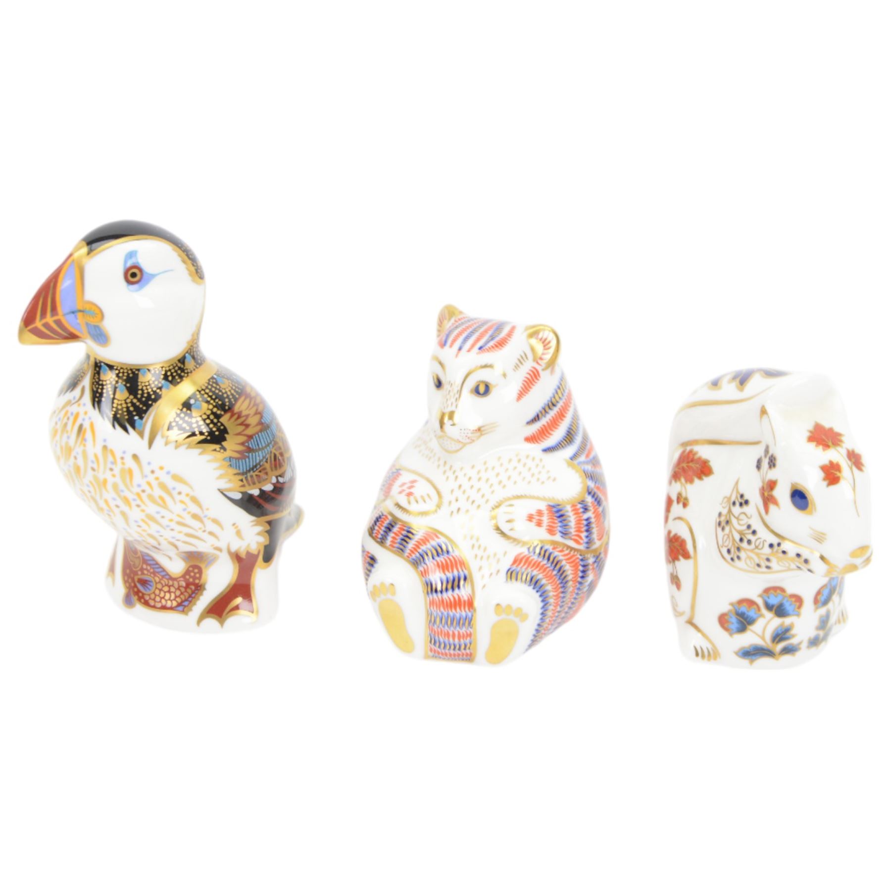 Four Royal Crown Derby paperweights, comprising Puffin, Squirrel, Badger, and Tiger Cub, each with silver stoppers