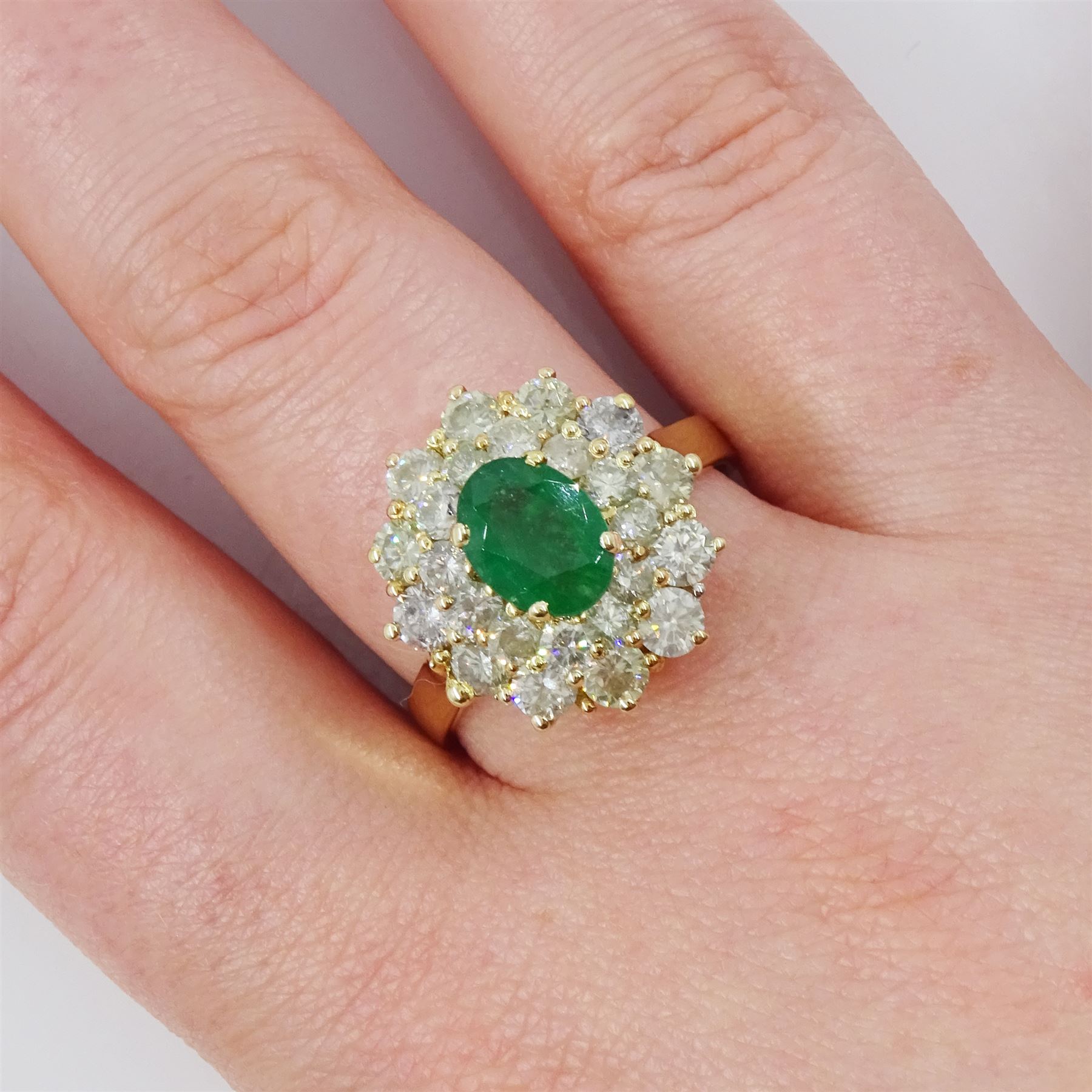 14ct gold emerald and diamond cluster ring, single oval cut emerald of approx 1.05 carat, surrounded by two rows of twenty four round brilliant cut light yellow diamonds, total diamond weight approx 2.35 carat