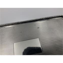 1920's silver table cigarette box, of rectangular form with engine turned decoration to the exterior, the hinged cover with central vacant rectangular panel and raised foliate rim, opening to reveal a gilt interior with later plush lining, hallmarked Charles Henry Dumenil, London 1923, H3.5cm L14.5cm D8.5cm