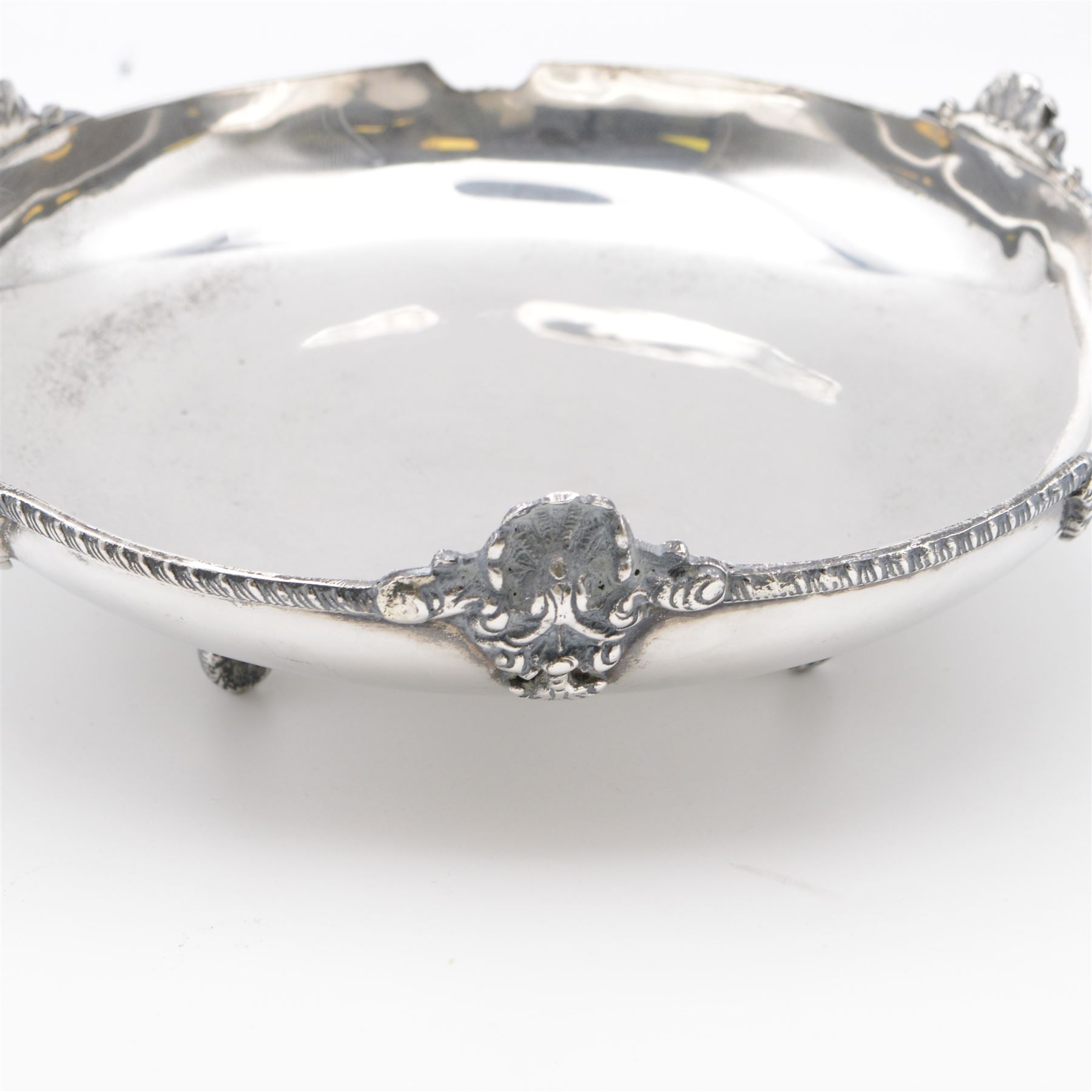 Egyptian silver bowl, of circular form, with oblique gadrooned rim and cast palmette decoration, upon three scroll feet, marked for 900 fineness, D20cm