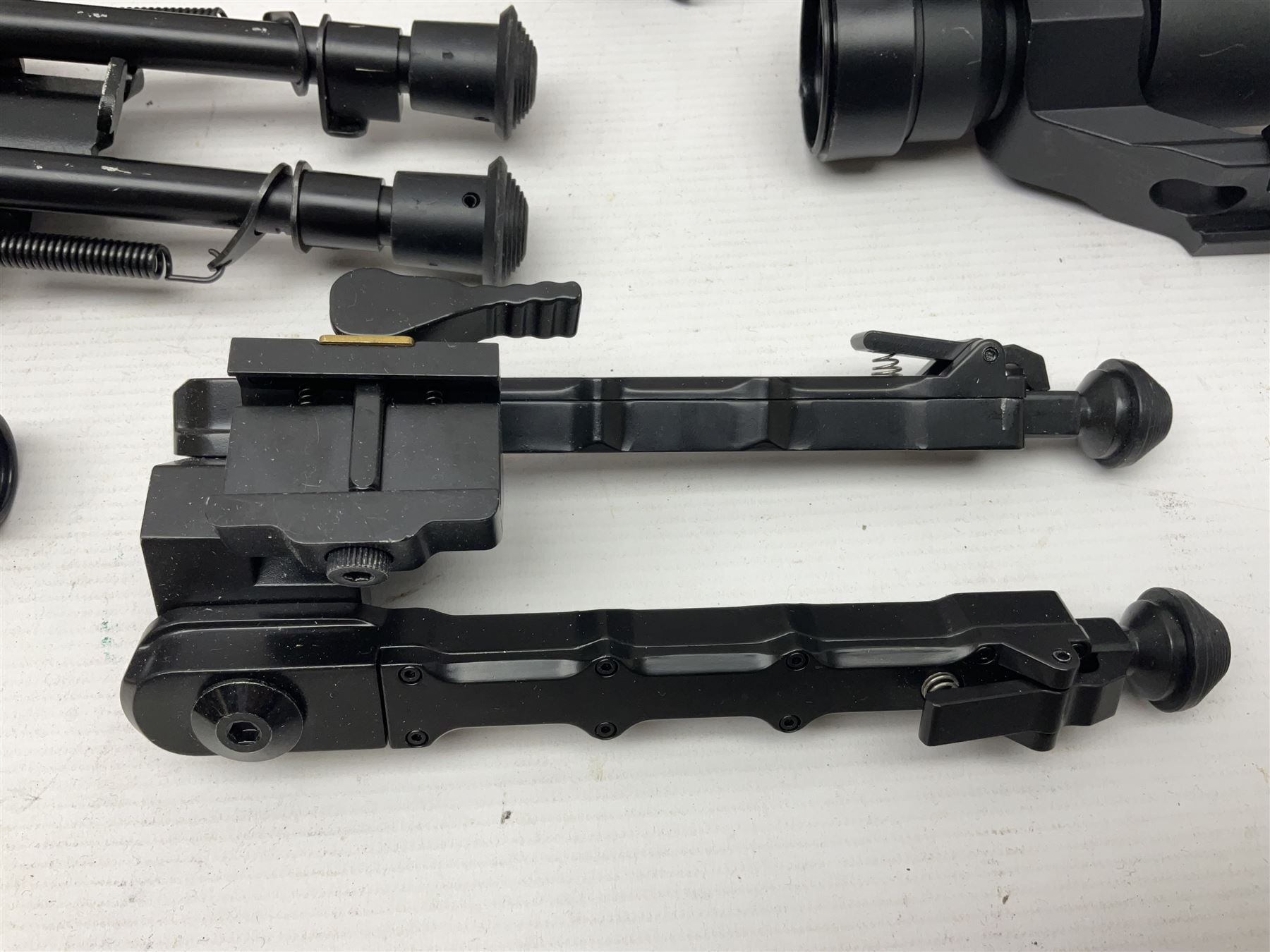 Assorted shooting accessories including two telescopic sights, red dot sight,  two bi-pods, spirit level mount, two gun butts and two forward handles