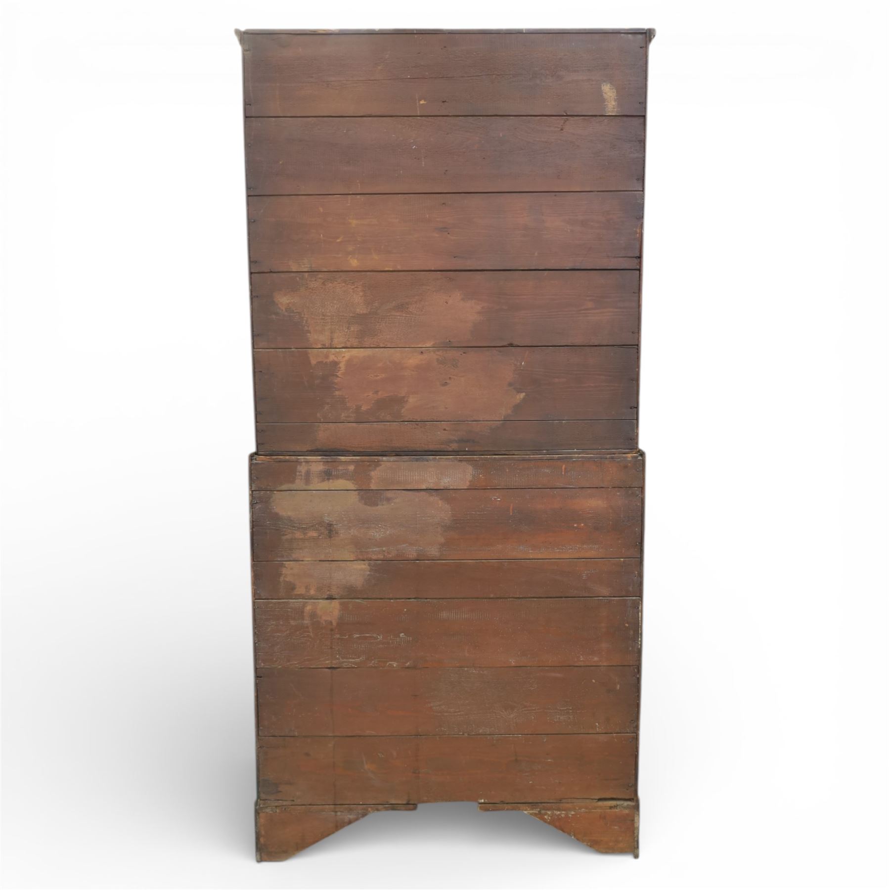 18th century oak press cupboard on chest, the moulded cornice above a pair of fielded panel doors enclosing shelved interior, the base fitted with four long graduated drawers with brass swan neck handles and shaped escutcheons, raised on bracket feet