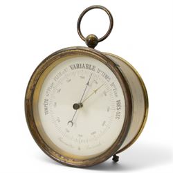 French- late 19th century desktop aneroid barometer in a circular gilt metal case with carrying ring, 3.5 inch paper printed register with predictions and barometric air pressure, with a steel indicating hand and brass recording hand, adjustment screw to the rear.