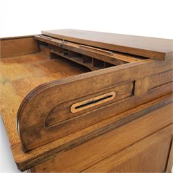 Globe Wernicke - Oak roll top desk, fitted with nine drawers, oak tambour roll top revealing a fitted interior, with single frieze drawer, flanked by four drawers to each pedestal, on a plinth base