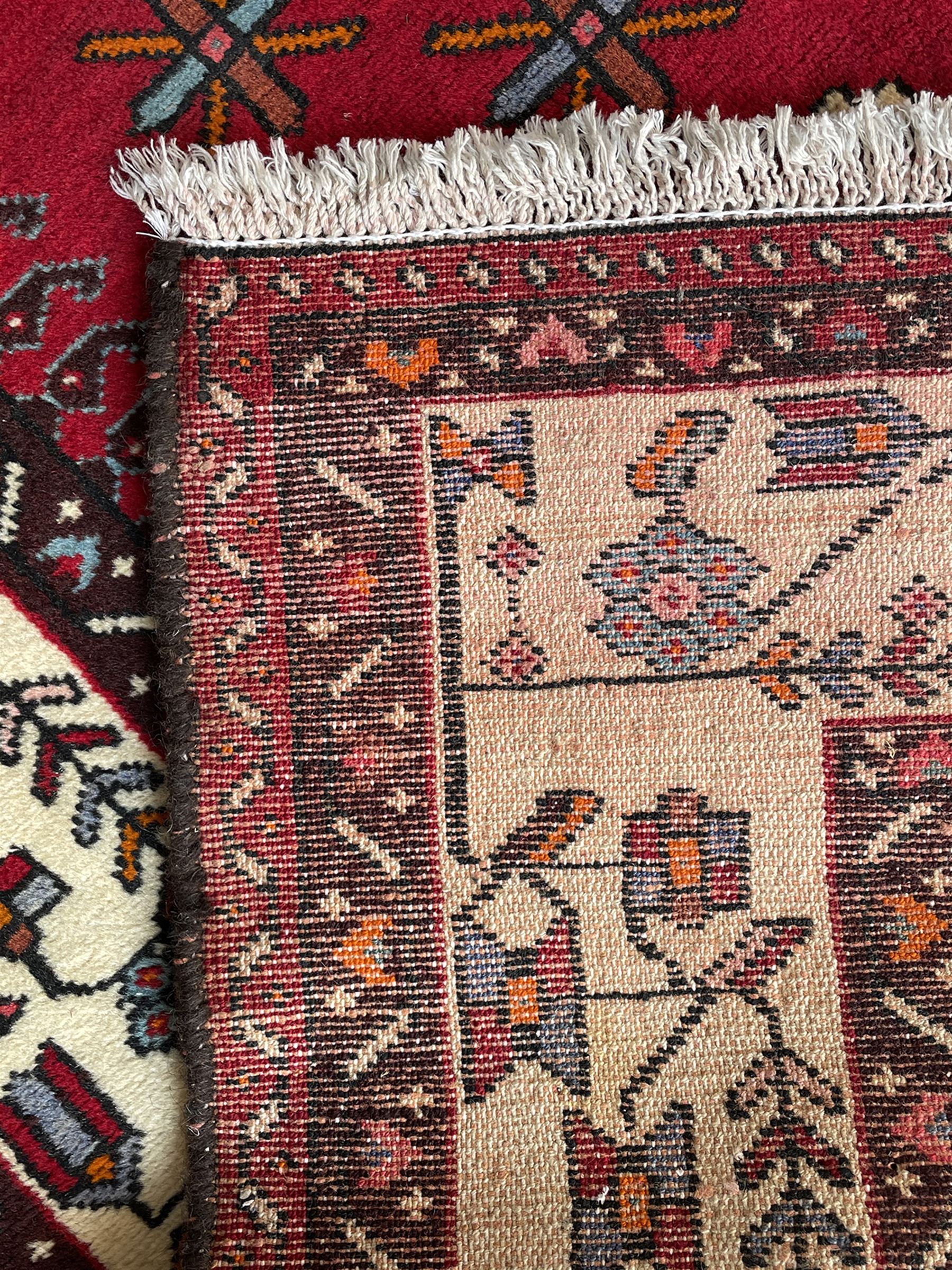 Persian Hamandan rug, the red ground field decorated with triple medallions and stylised motifs