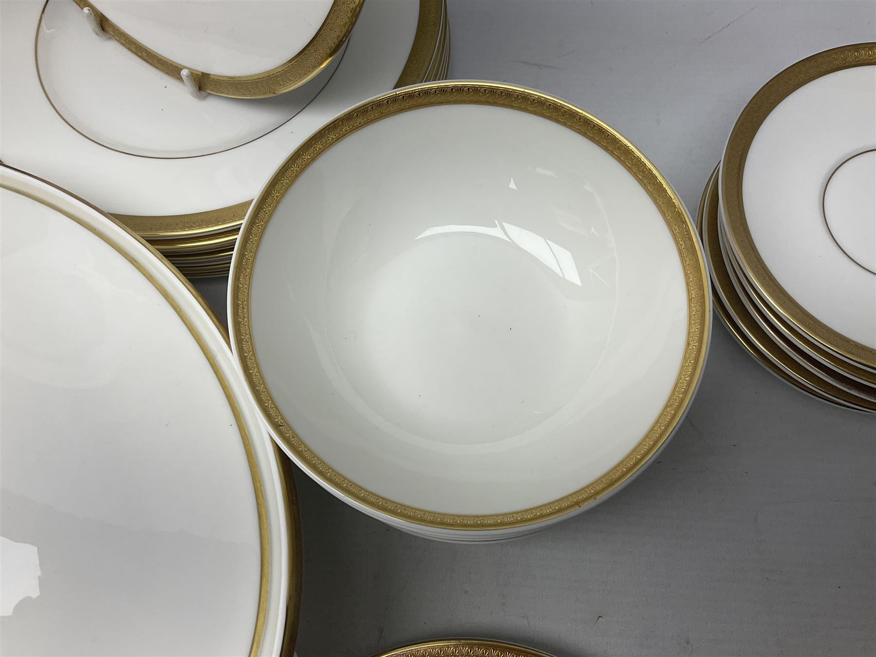 Royal Doulton Royal Gold pattern tea and dinner service for eight, comprising dinner plates, side plates, tea plates, soup bowls, sauce boat and saucer, dessert bowls, coffee cans and saucers, teacups and saucers and two lidded tureens