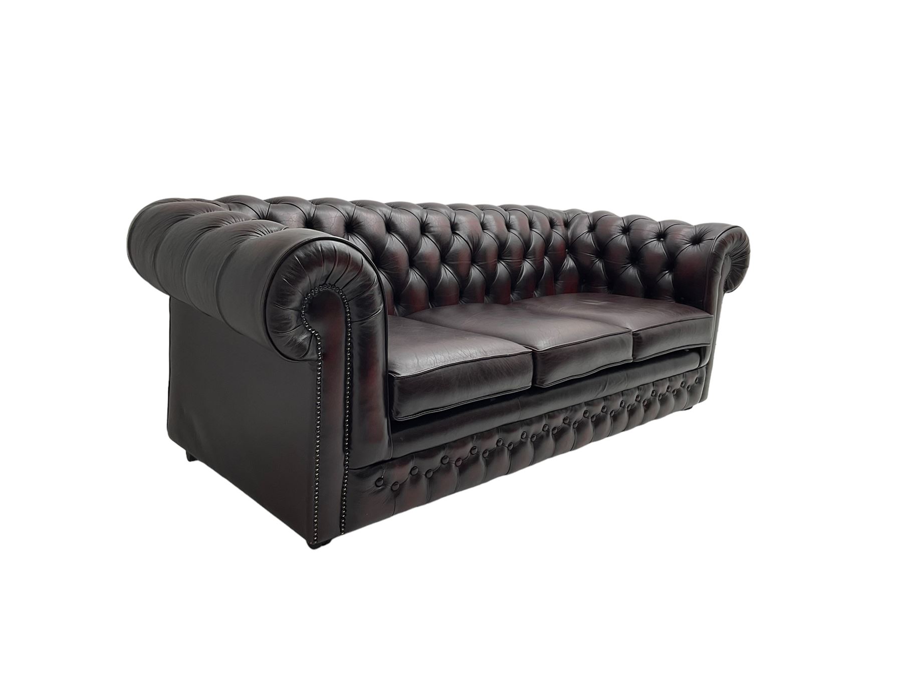 Thomas Lloyd - three seat Chesterfield sofa, upholstered in buttoned oxblood leather, on castors 