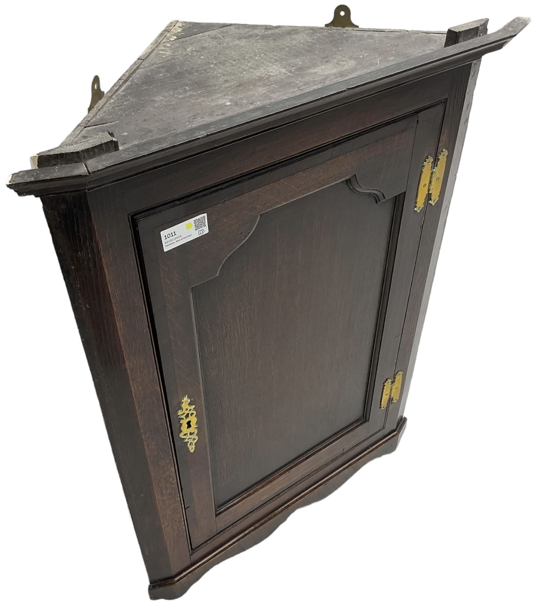 George III oak wall hanging corner cupboard, projected cornice over crossbanded and fielded panelled door, enclosing three shelves