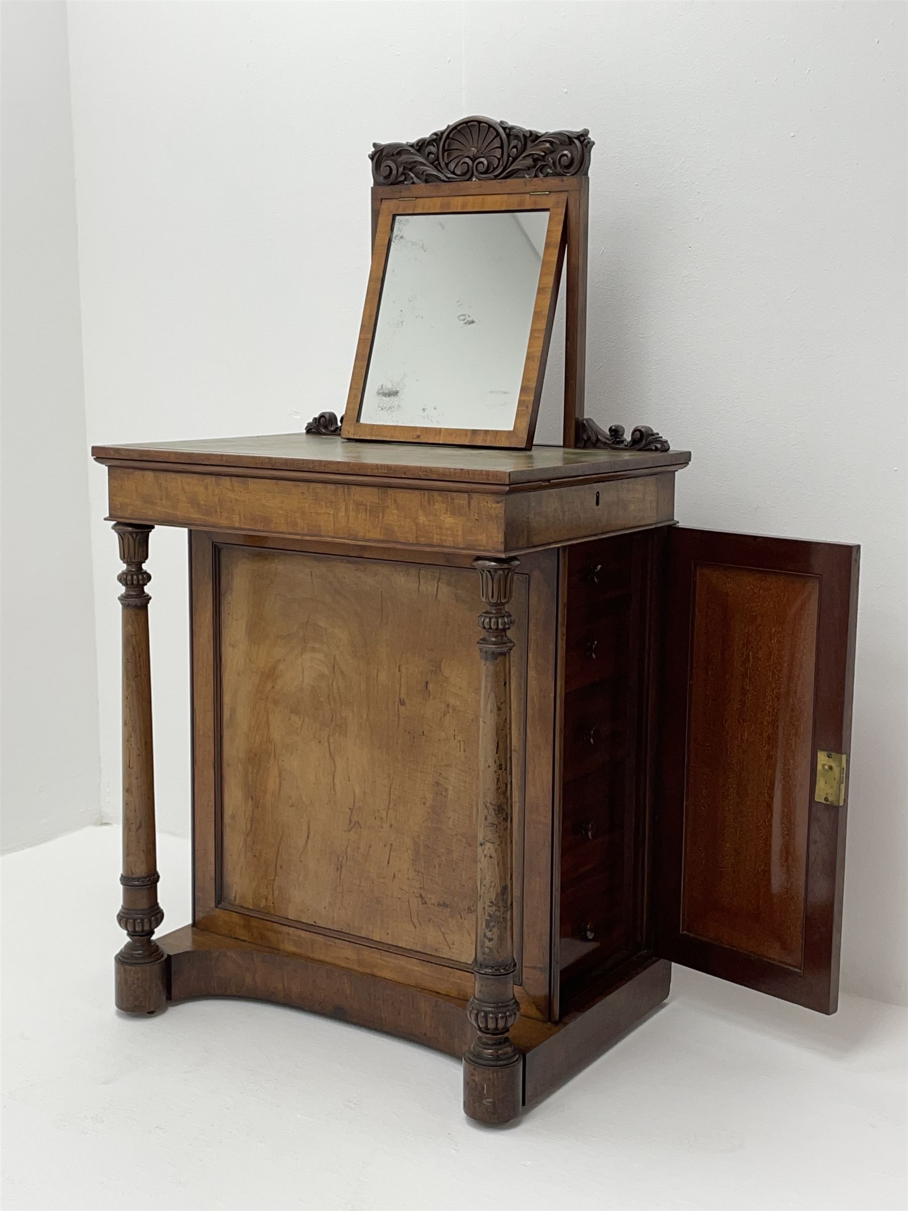 Early Victorian figured mahogany dressing cabinet, the raised shell and scroll carved back lifts to reveal rectangular easel mirror with mahogany band, flat rectangular top with tooled leather inset, slide at each side with matching leather inset, full width drawer above cupboard enclosing a series of five drawers, turned front supports, panelled front, sides and back