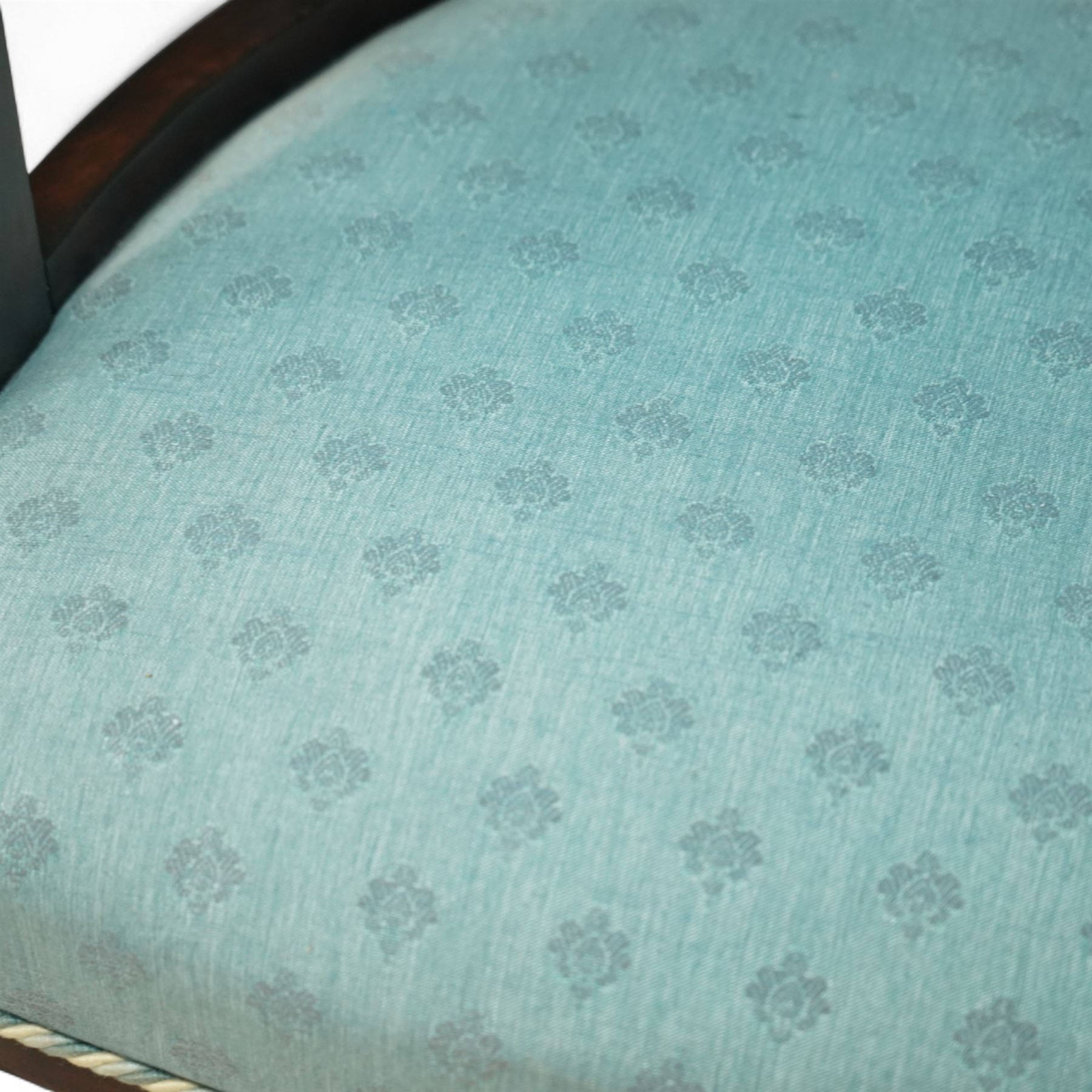 Late Victorian mahogany upholstered tub chair, curved button-back with rope-edge trim over open shaped arms and pierced splat supports, rounded seat upholstered in patterned blue fabric, raised on cabriole front supports