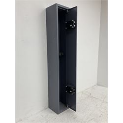Grey steel wall mounting gun cabinet to accommodate three guns; single door with two locks with two keys for one lock; internally H128.5cm W21cm D17.5cm; externally H129cm W21.5cm D20cm