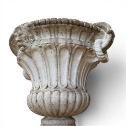 Pair of Neoclassical design cast stone garden urns, each of campana form with fluted body and gadrooned underbelly, decorated with faun/satyr opposing masks and ropetwist handles, with floral and mask design to the socles, raised on square bases, finished in weathered white patina