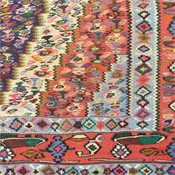 North West Persian Senneh kilim, finely woven wool with elongated central lozenge medallion on a densely patterned field of boteh motifs, in tones of red, ivory, indigo and ochre, framed by floral and diamond guard borders