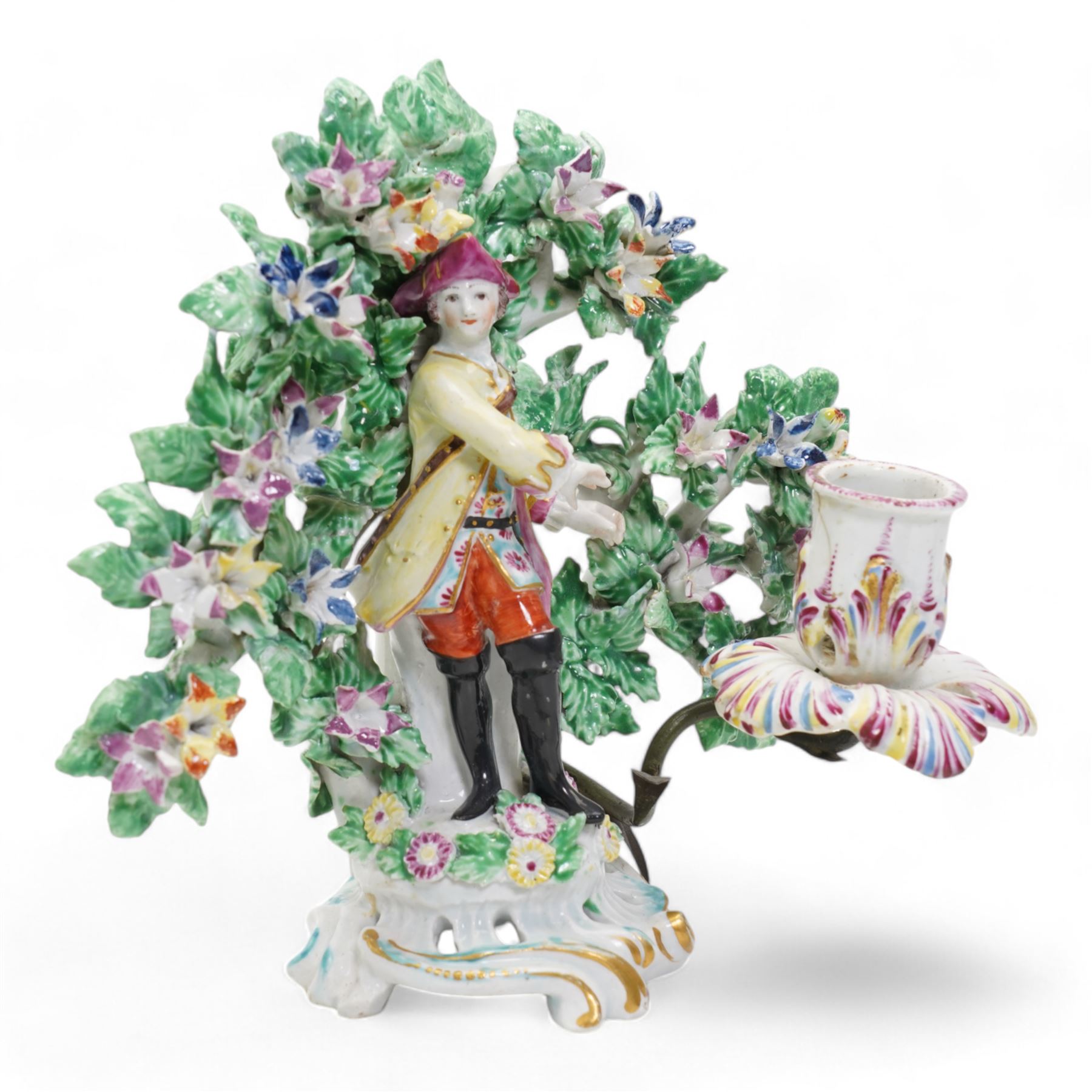 Pair of Bow porcelain 'New Dancers' candlesticks, standing before flowering bocages, and wearing brightly coloured flowered clothes, each supporting to left and right a tôle peinte branch terminating in a leaf moulded nozzle, on scrolling footed bases, red anchor and blue/red dagger marks beneath, H19cm x W18cm (2)