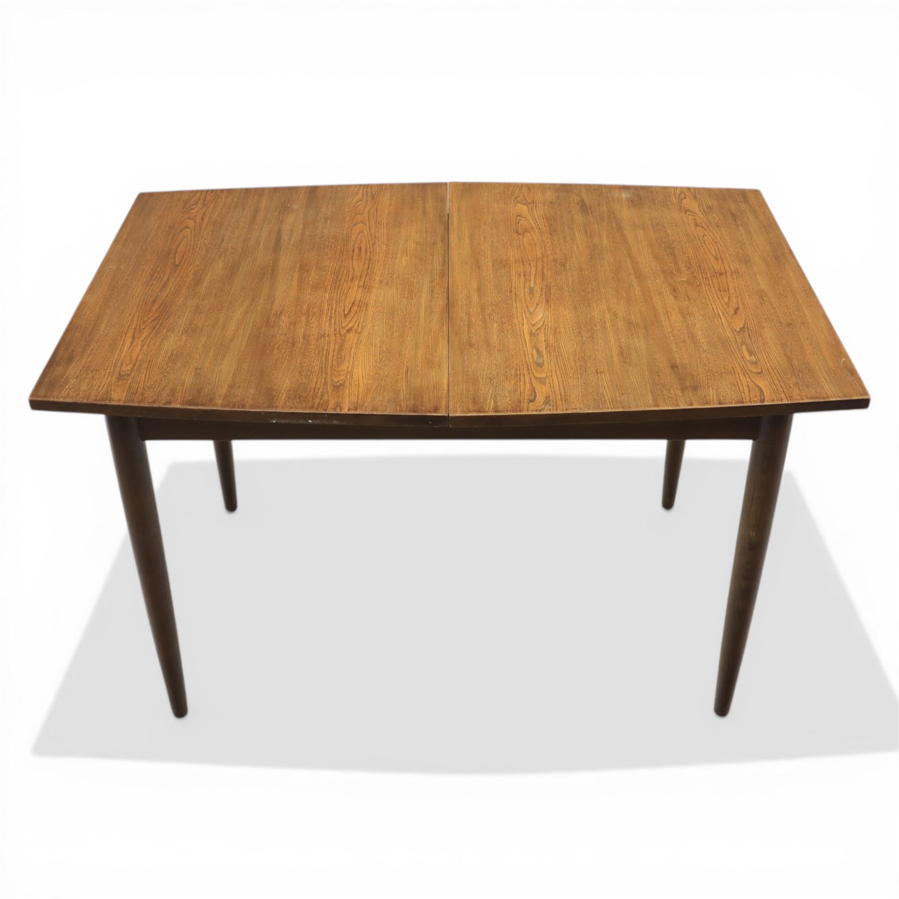 Ensign - Mid-20th century elm extending dining table, with fold out leaf, bow ends and sides; and four low stick back chairs, labelled Ensign Bristow & Townsend Ltd, extended 168cm