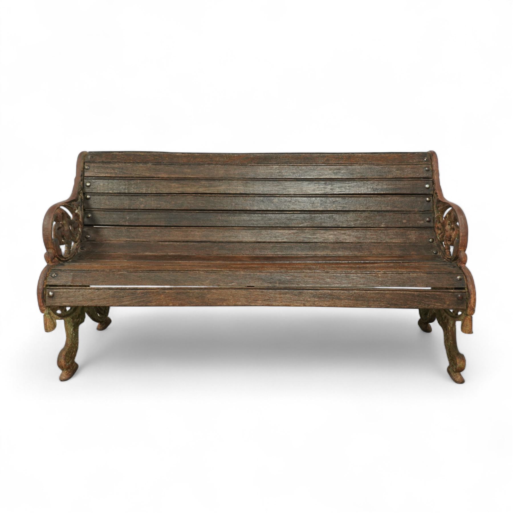 19th century oak and cast iron garden bench, shaped back and seat formed from curved wooden slats secured with dome rivets, pierced cast iron supports with foliate decoration 