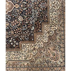 Large Persian indigo ground rug, the busy field decorated with trailing branches and flower heads, peach border decorated with palmettes -