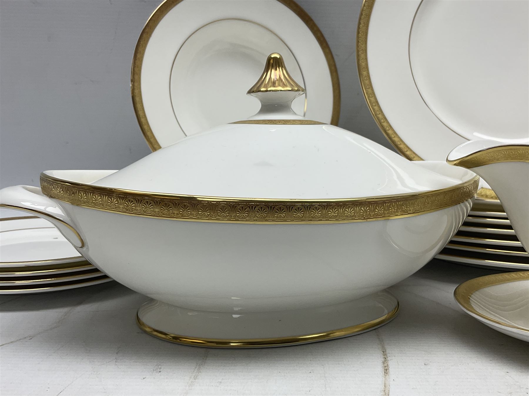 Royal Doulton Royal Gold pattern tea and dinner service for eight, comprising dinner plates, side plates, tea plates, soup bowls, sauce boat and saucer, dessert bowls, coffee cans and saucers, teacups and saucers and two lidded tureens