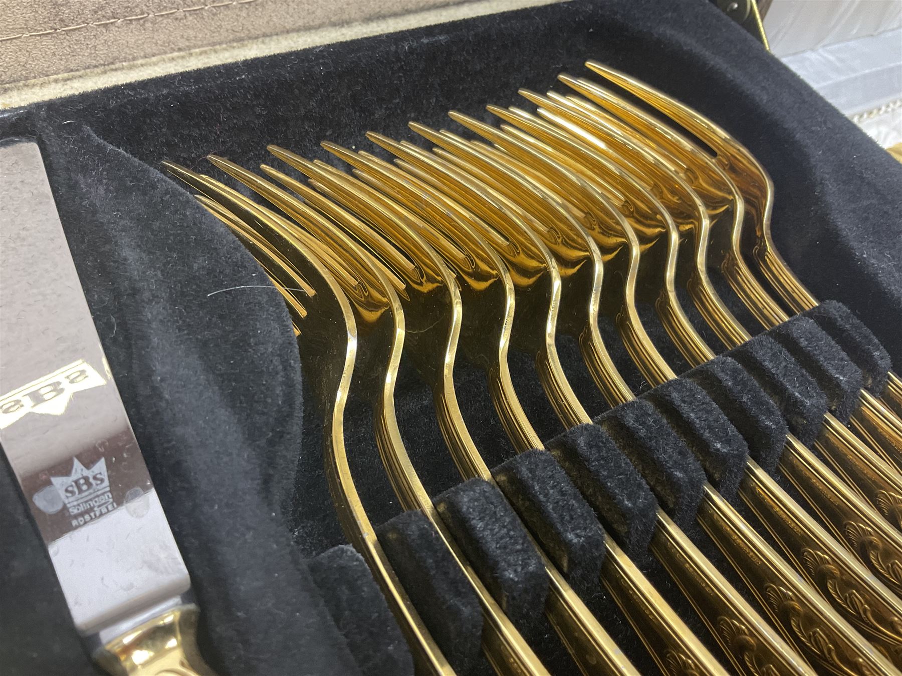 Bestecke Solingen canteen of gold plated cutlery for twelve place settings, including ladle, cake slice and serving spoons, contained within a briefcase, together with a matching set twelve of Bestecke Solingen gold plated fish knives and forks, in fitted case 