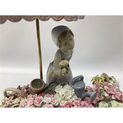 Lladro figure, Flowers of the Season, modelled as a flower seller with cart and baskets profusely decorated with encrusted flowers, beneath an umbrella surmounted with birds, numbered beneath 1454, H27cm