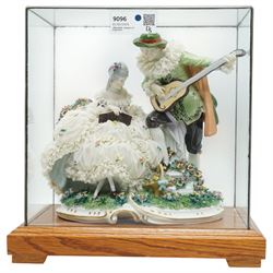 Unterweissbach style porcelain figural group of a seated lady with a gentleman playing a lute, stamped 'Foreign' to base, in bespoke display case