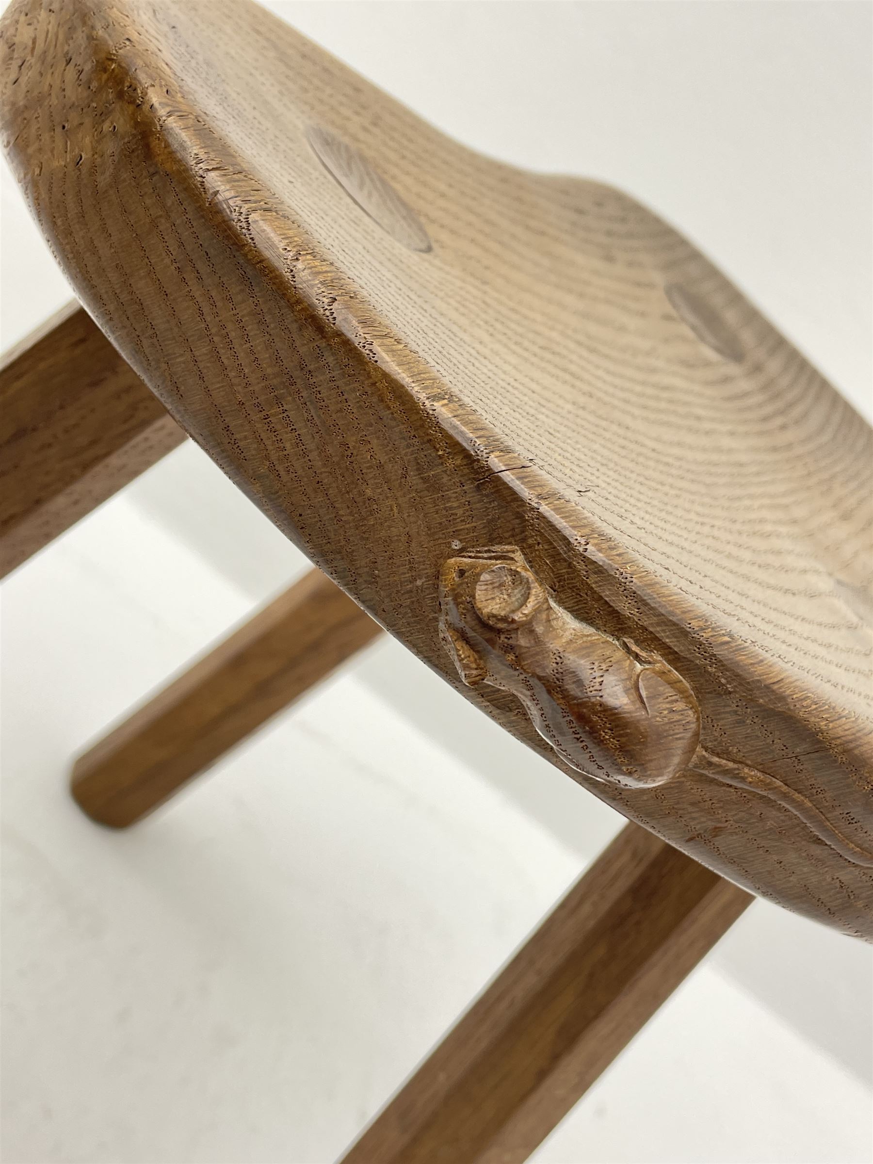 'Mouseman' oak three legged stool with dished kidney shaped seat, tapered octagonal supports, with carved mouse signature, by Robert Thompson of Kilburn 