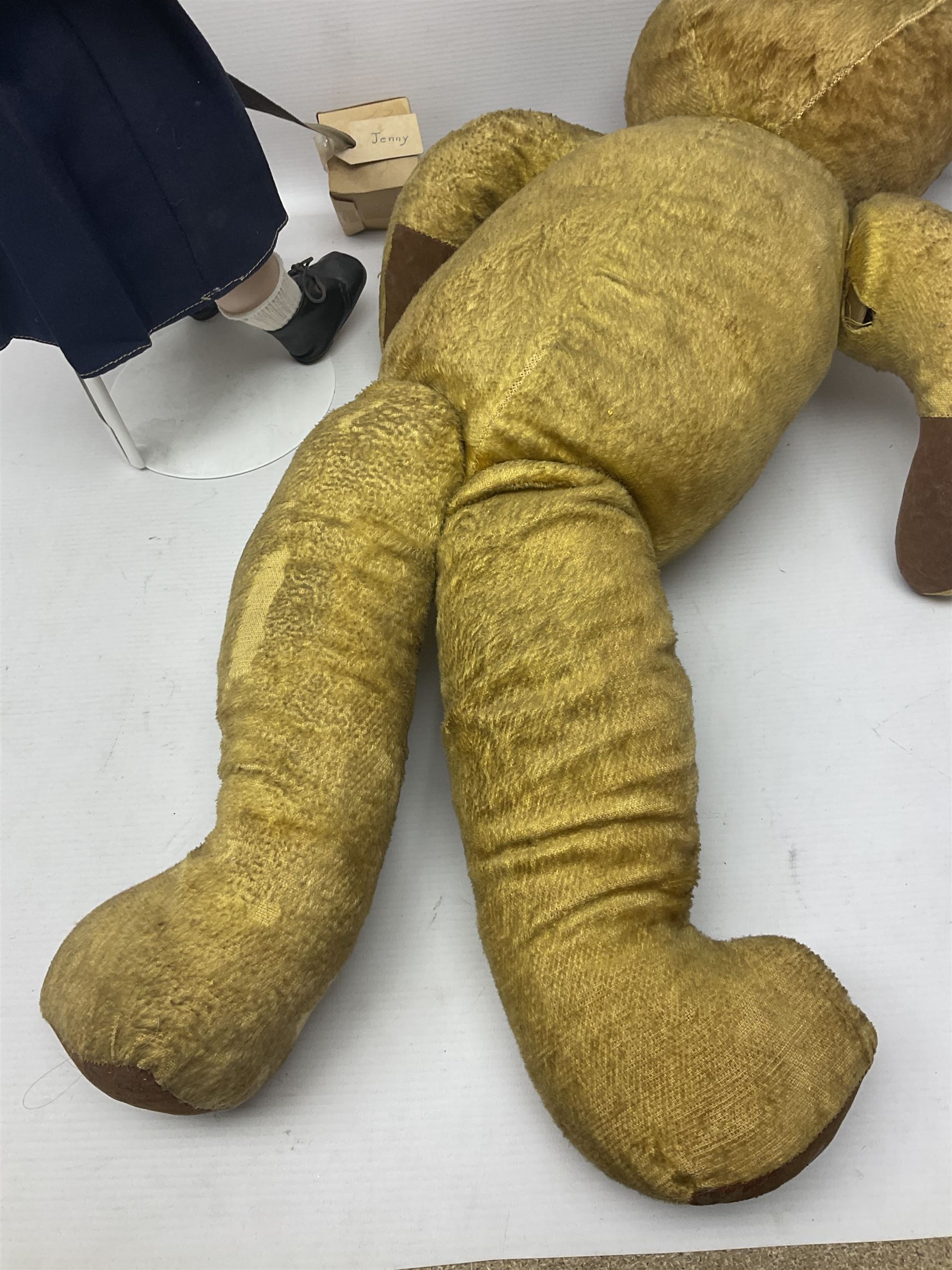 Mid-20th century woodwool filled teddy bear; and porcelain doll dressed as a WW2 evacuee