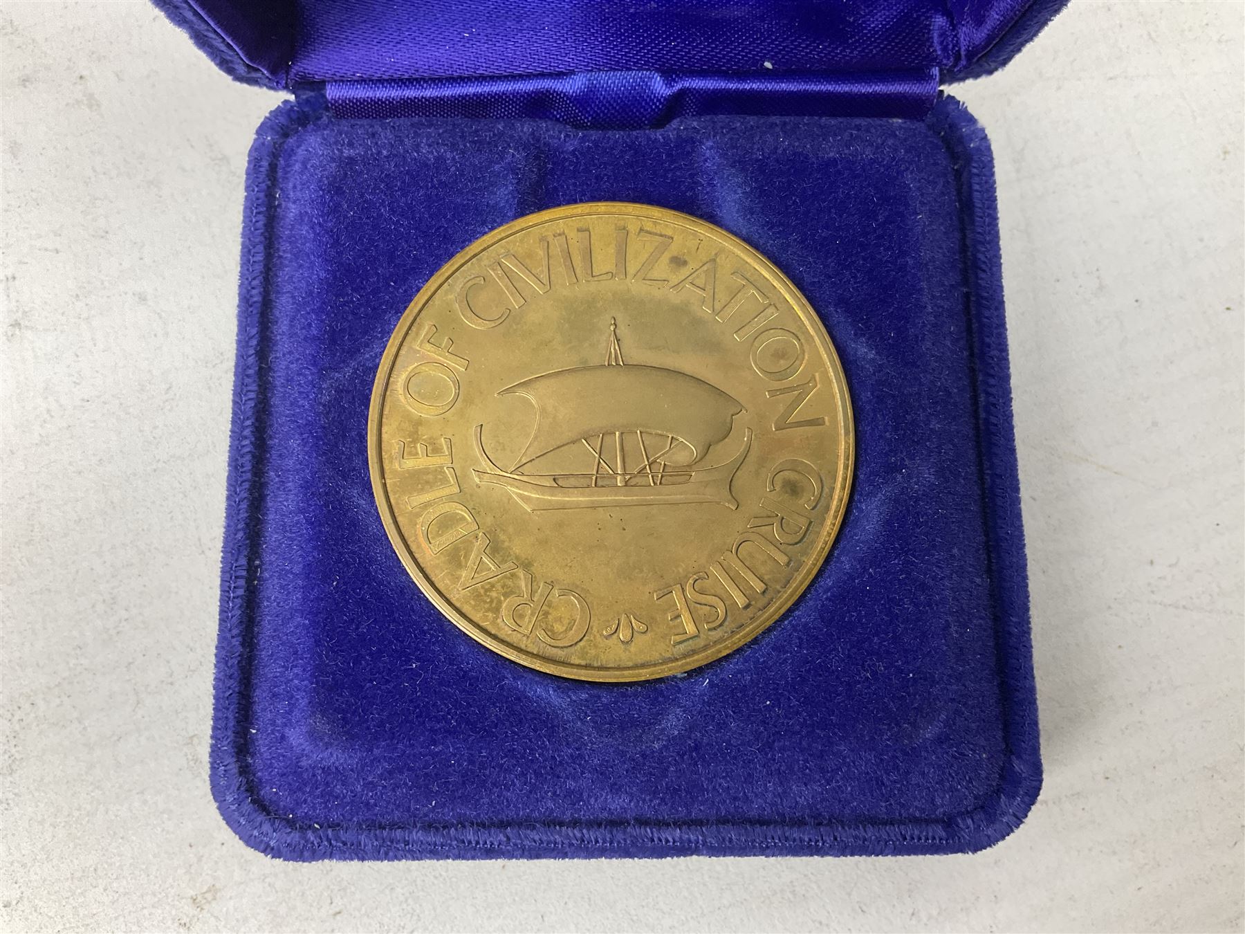 Queen Elizabeth II cradle of civilization cruise 1976 bronze medallion with related book and two other Queen Elizabeth II commemorative medallions for cruises in 1975 and 1976, all cased