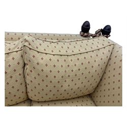20th century Knole design two seat sofa, high back and double drop-arm joined by mahogany finials and ties, upholstered in camel ground fabric with red lozenge design, on turned supports with brass castors