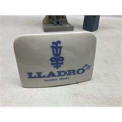 Two Lladro figures, comprising Conductor no 5196 and Prayerful Moment no 5500 together with a Lladro plaque and two Lladro candle holders, Dolphins at Play no 17666 and Sailing the Seas no 17665, all with original boxes, largest example H33cm 